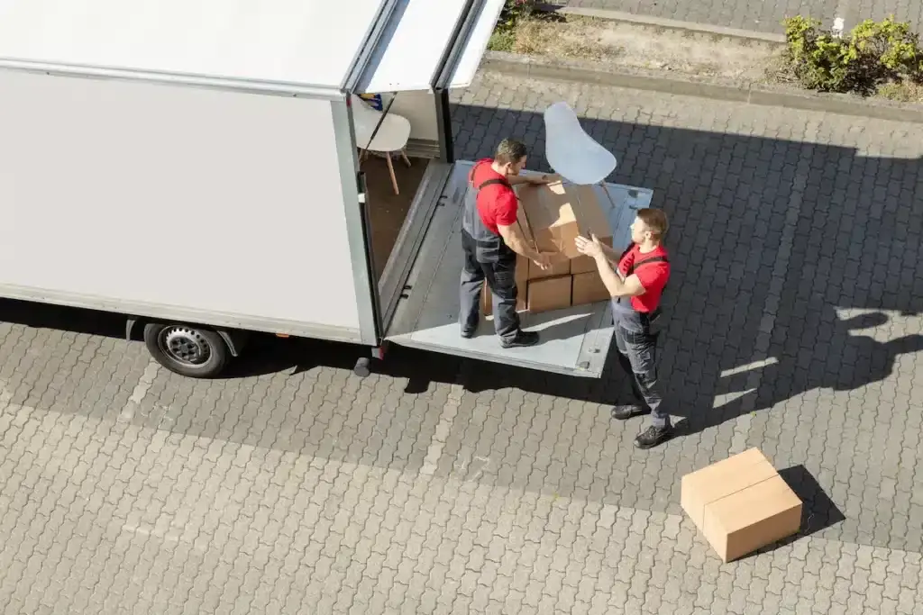 Déménageurs emballant et chargeant des meubles dans un camion de déménagement